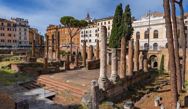 Largo di Torre Argentina square in city of Rome, Italy, ancient temple ruins (4 century BC – 1st century AD) and Teatro Argentina (1731) opera house and theatre in the background.